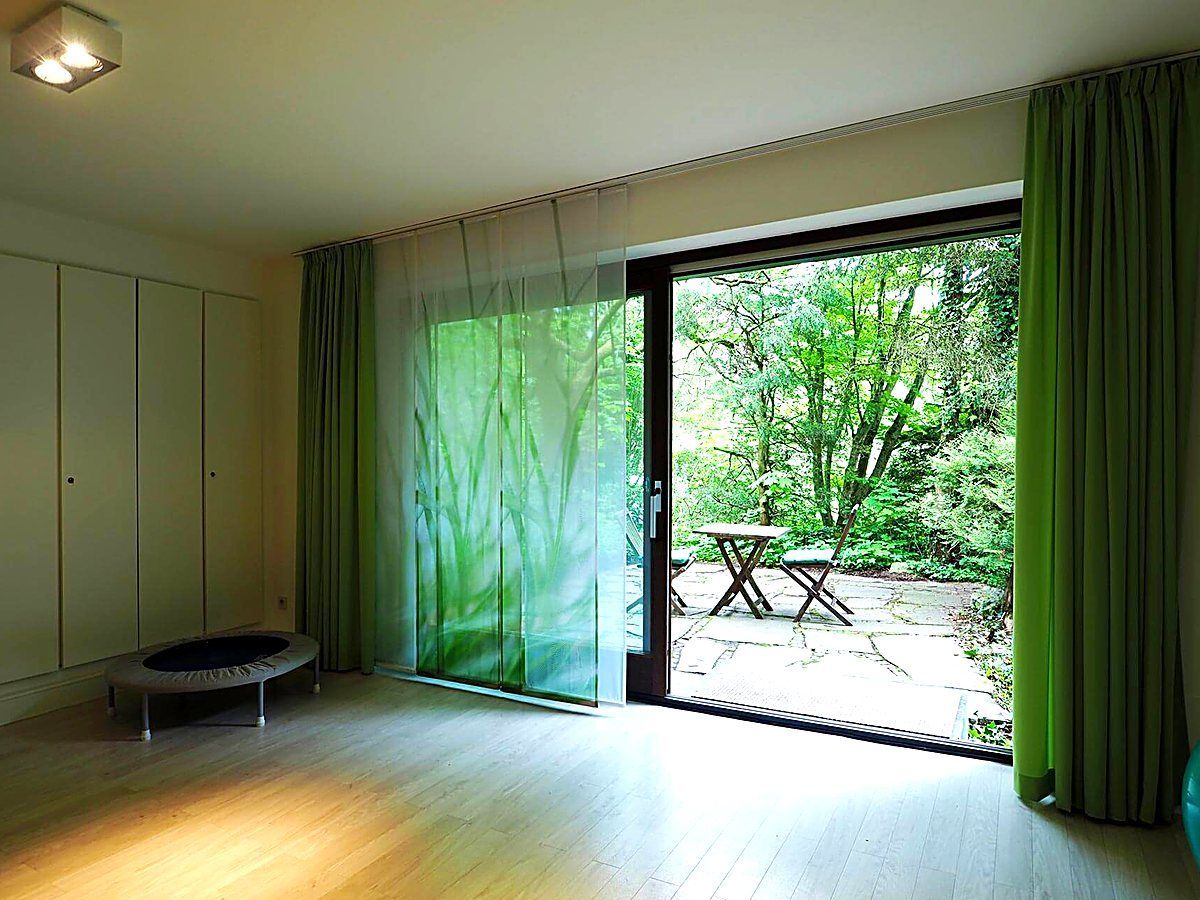 Heller Behandlungsraum mit Tageslicht und Blick in den Garten bei Heal and feel